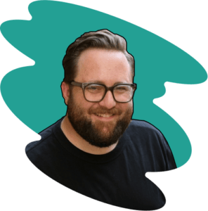 A person with a beard and glasses is smiling like a friendly local sherpa guide, set against a teal abstract background. They are wearing a black shirt.